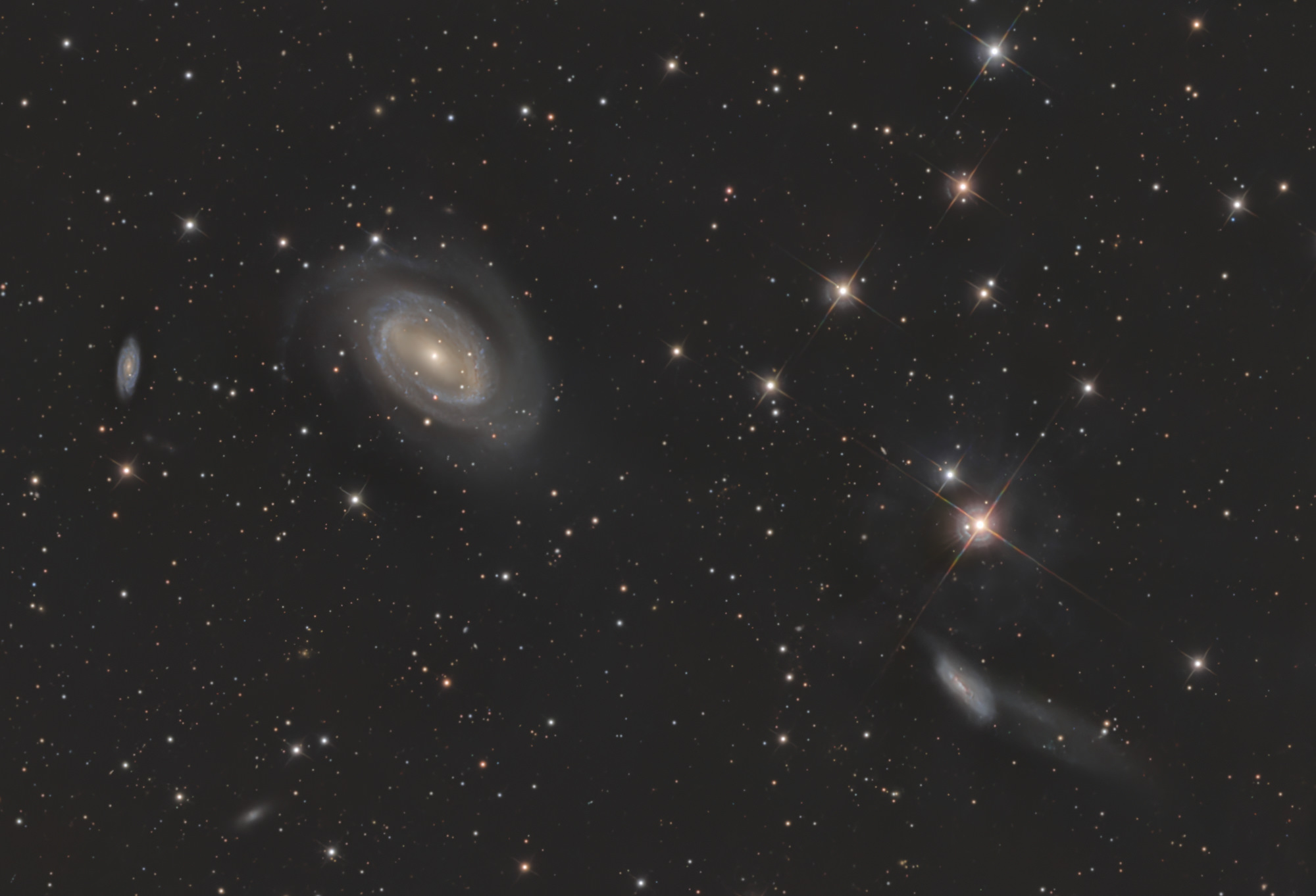 Das Holmberg-468-Galaxientriplett im Sternbild Coma Berenices enthält von links nach rechts die Galaxien NGC4712, NGC4725 und NGC4747. Die große Galaxie NGC 4725 interagiert mit der benachbarten Galaxie NGC 4747 rechts unten im Bild und besitzt ein extrem massereiches Schwarzes Loch im Zentrum.